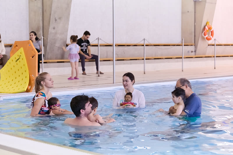A Baby Seal class at the North York teaching pool, parents holding their babies with the swim teacher facing them.